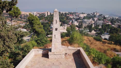 stone monument on hilltop overlooking city and valley
