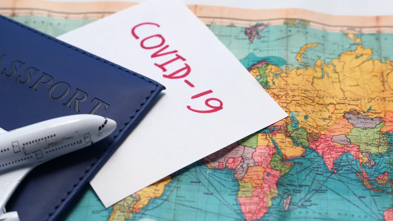Passaporto, aereo e mappa del mondo con COVID-19