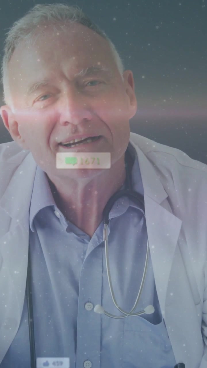 Vertical video: Senior doctor writing, UI appearing causing head raise, speaking to camera, smiling