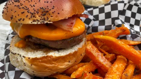 una sabrosa hamburguesa con queso con tocino, un pan de brioche y patatas fritas, comida estadounidense poco saludable, un tiro de 4k