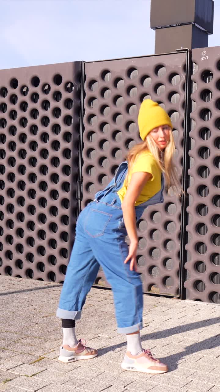 Woman in Yellow Beanie and Overalls Posing Outdoors