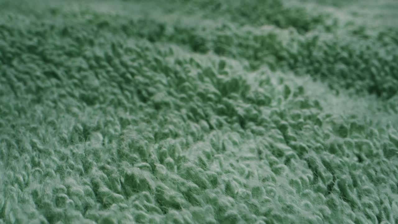 A captivating view of luxurious plush green fabric that highlights its incredibly soft texture and vibrant color