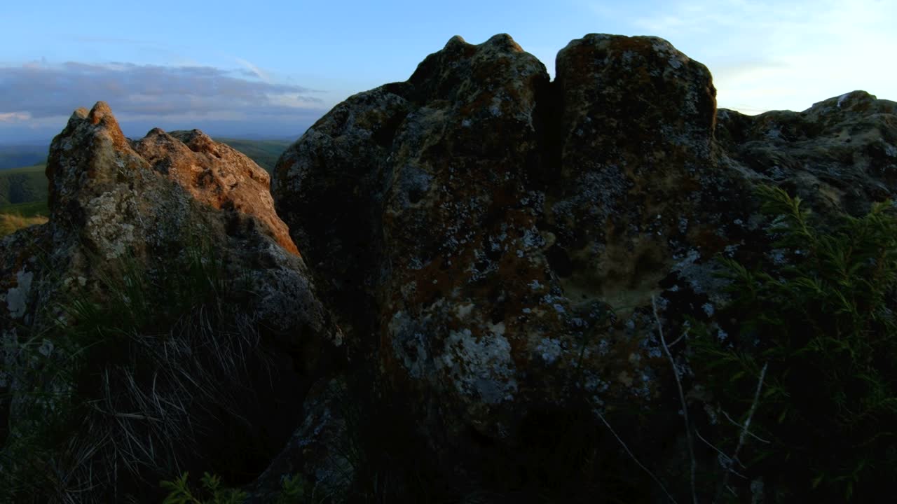 산꼭대기 위에 해가 지는 어두운 열, 산에서 해가 지고 있는 빛, 파랄락스 바위, 바위 잔디.