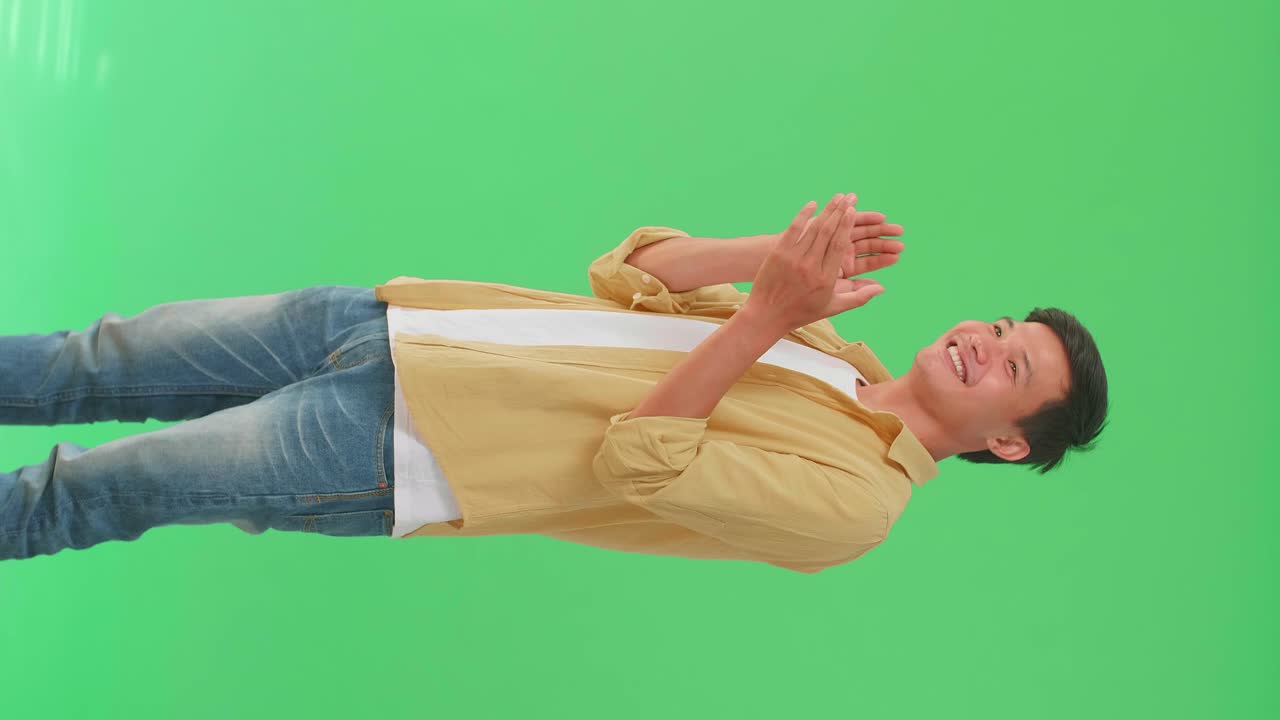 Young Asian Man Clapping Her Hands In The Green Screen Studio
