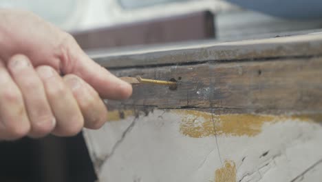 asegurando un tornillo de bronce en un barco de madera gunwale interior