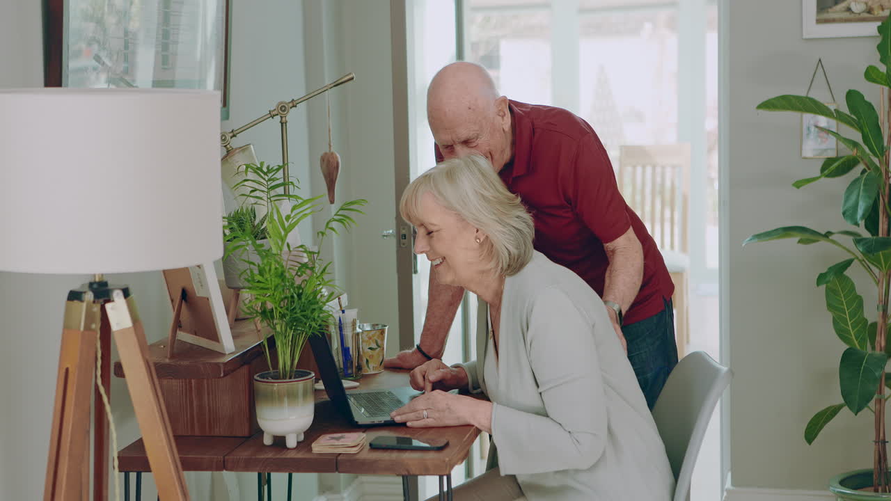 Senior couple using a laptop together at home
