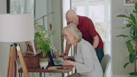 una pareja de ancianos usando una computadora portátil juntos en casa