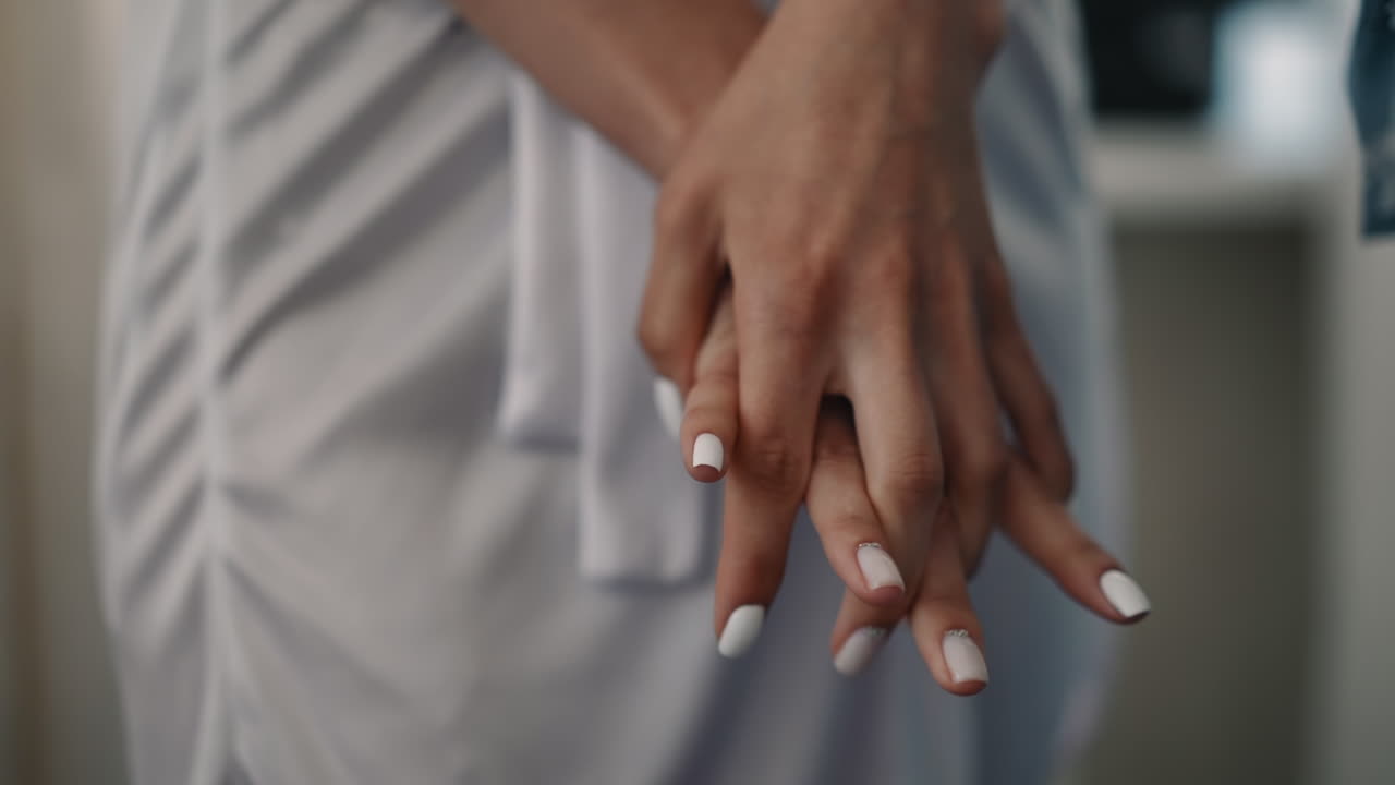 Mulher com manicure branca faz ginástica para dedos
