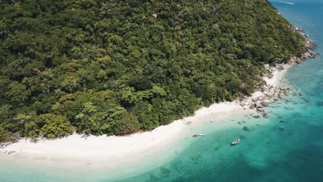 Drone-aerial-parallax-with-boats-in-tropical-blue-clear-water-and-rocks-on-a-sunny-day