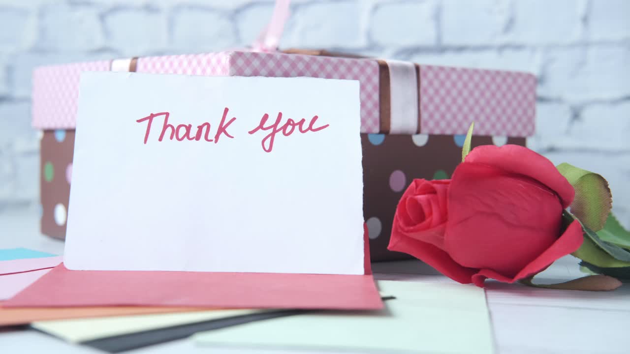 tarjeta de agradecimiento con caja de regalos y rosa