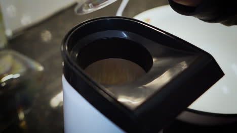 pouring popcorn kernels into a popcorn machine