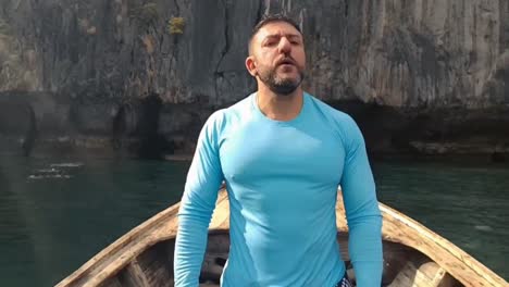 hombre en la punta de un barco de cola larga tailandia