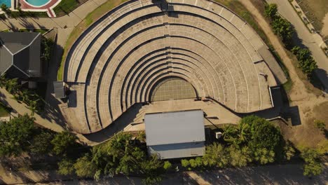 a dynamic pivoting aerial shot above the villa maria amphitheater in córdoba city of argentina while it gradually descends to it