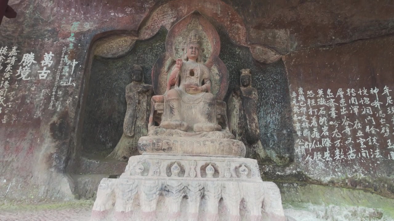 Grotte di Shibaoshan Shizhongshan, primo piano dal basso di una statua di Guanyin Bodhisattva scolpita nella pietra con antiche iscrizioni.