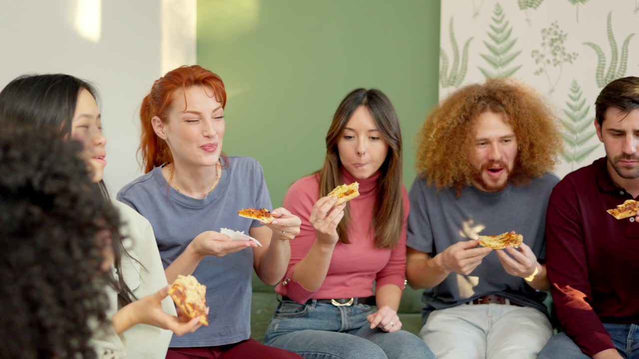 Friends chilling and smiling eating pizza together at home