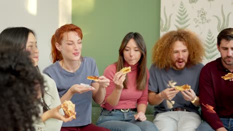 friends chilling and smiling eating pizza together at home