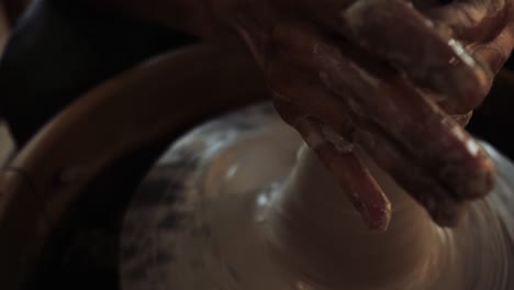 beautiful close-up shot of wet male hands working with clay on a potter's wheel