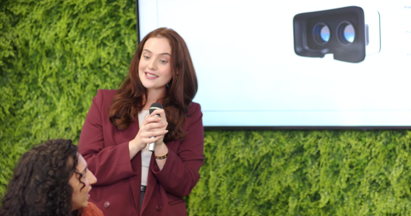 Moderator raising mic and offering to presenter, presenter accepting and explaining VR predictions
