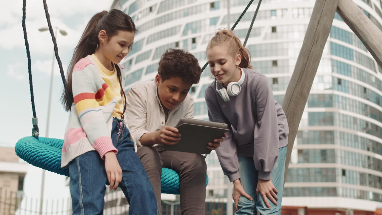 School Children Playing on Digital Tablet Outdoors