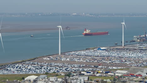 Vista-Aérea-De-Teleobjetivo-Rastreando-Un-Barco-De-Contenedores-Que-Pasa-Por-El-Puerto-De-Sheerness,-En-La-Isla-De-Sheppey,-Kent,-Reino-Unido