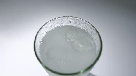 vista superior, vertiendo agua gaseosa en vasos, cubitos de hielo, sirviendo bebidas