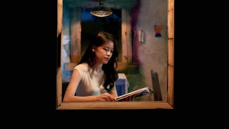 Asian-girl-reading-book-at-the-window,-static