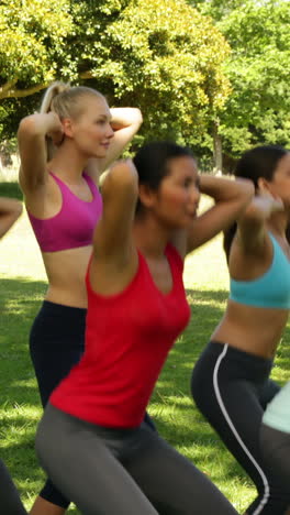 clase de fitness haciendo secuencia de sentadillas juntos