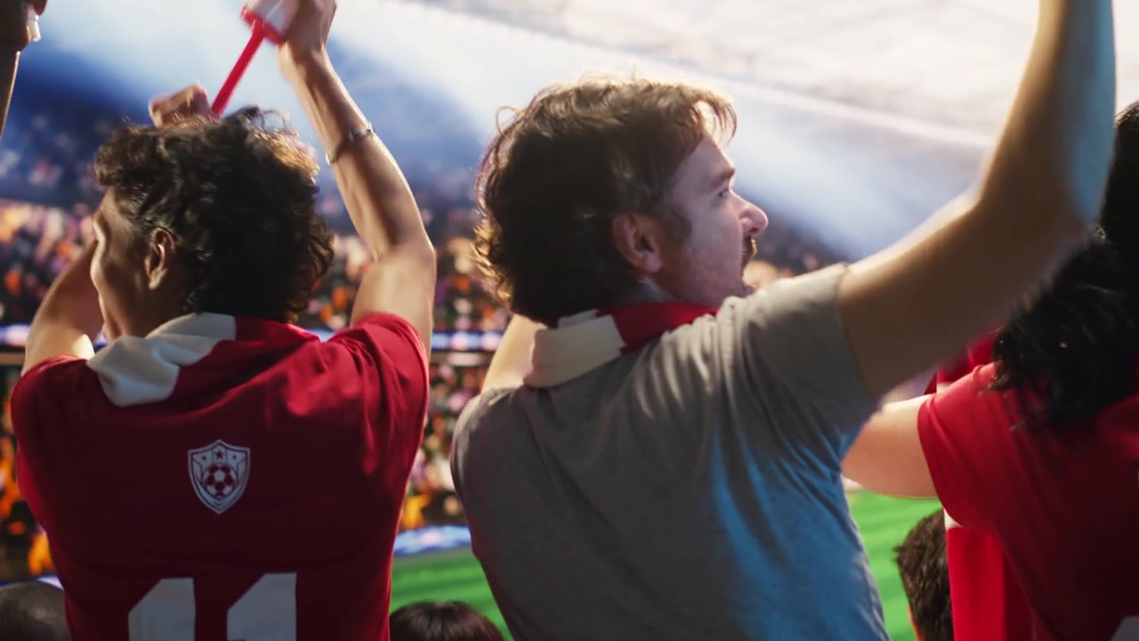 Primer plano de un aficionado al fútbol haciendo ruido con vuvuzelas y cornetas de aire durante un partido.