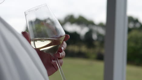 bride to be holding white wine glass outdoors, slow motion