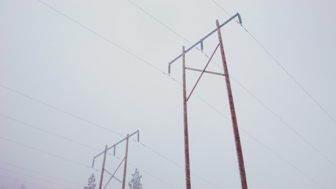 широкий снимок высоких линий электропередач во время снегопада