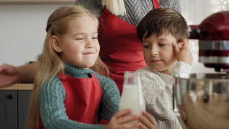 video of little girl pouring milk into  electric mixer bowl