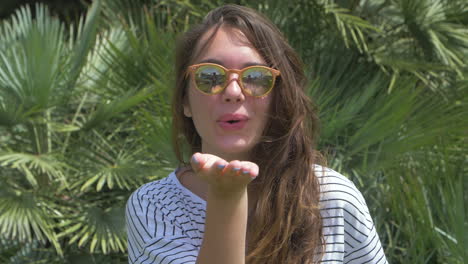 mujer con gafas de sol sonriendo en el jardín