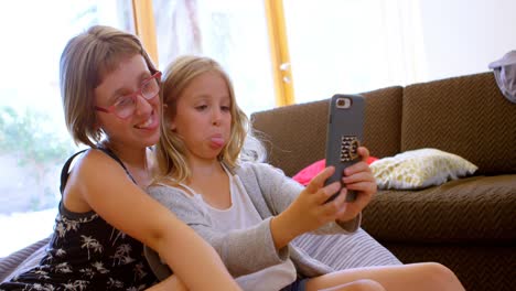 Geschwister-Machen-Selfie-Mit-Mobiltelefon-Im-Wohnzimmer-4k