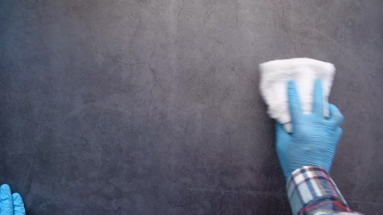 limpieza de una encimera gris oscuro con guantes