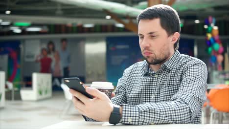 hombre usando un teléfono inteligente en un café
