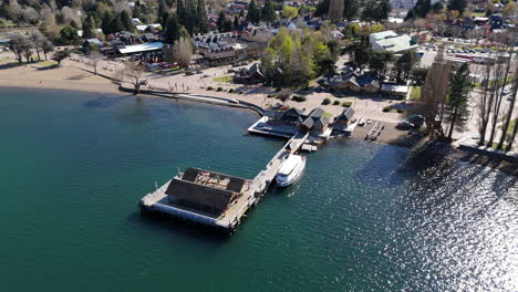 aerial view of picturesque wooden pier with boat on lácar lake in san martín de los andes, neuquén, patagonia argentina