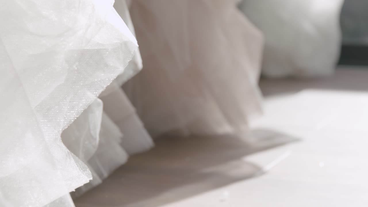 A close-up of the bottom of a wedding dress in a wedding salon