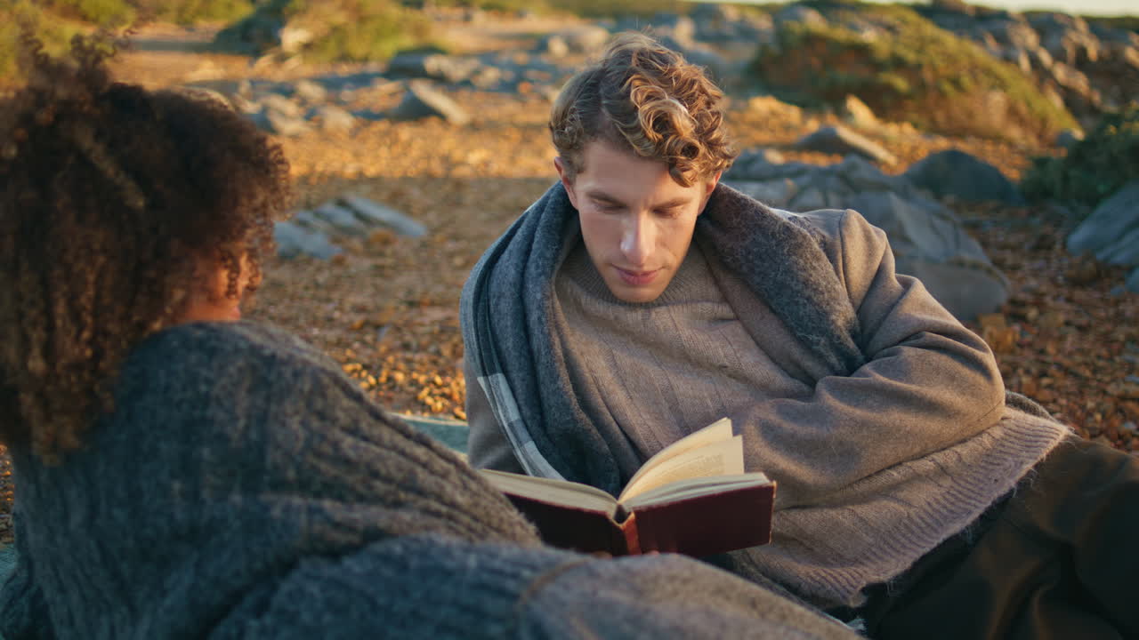 Relaxed lovers reading novel spending weekend together closeup. Man woman lying