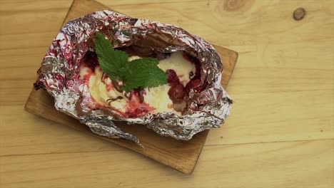 postre de helado en papel con colato y frambuesas, dulce