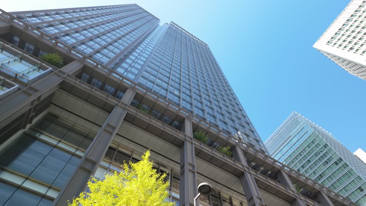 A striking upward perspective of sleek buildings around Marunouchi Square, capturing Tokyo's urban grandeur.