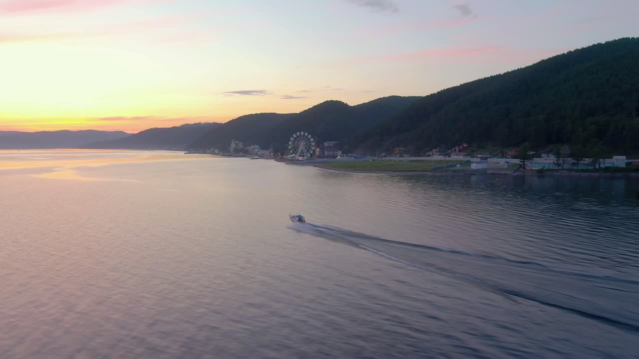 페리스 과 보트와 함께 호수 위의 해가 뜨는 것