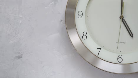 un minuto después de las cinco en el reloj de pared con tiempo en movimiento continuo
