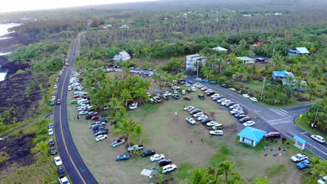 gathering of cars and people at a beach side lawn on hawaii island