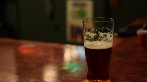 beer sitting on a bar with colored disco lights in the background