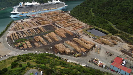 Pine-Logs-awaiting-export-at-Waimahara-log-Wharf,-Picton,-New-Zealand,-aerial-view