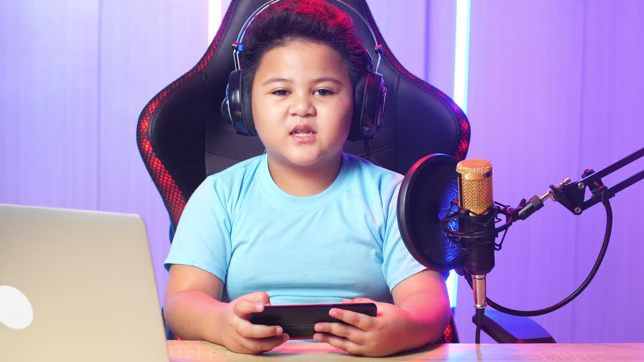 Asian Little Boy Holding Mobile Phone And Talking To Camera While Live Stream