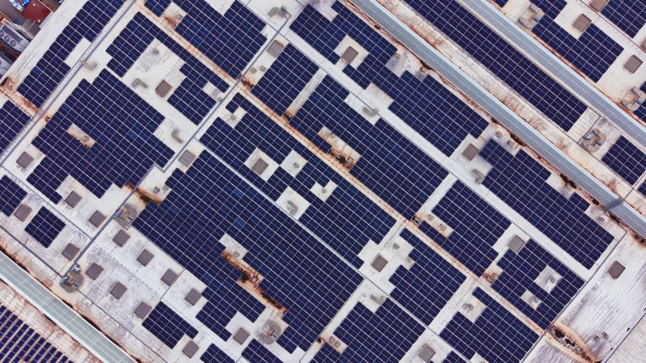 Pannelli solari coprono un grande tetto in una città, mostrando lo sforzo di utilizzare energia pulita nelle aree urbane, massimizzando lo spazio durante le giornate di sole.
