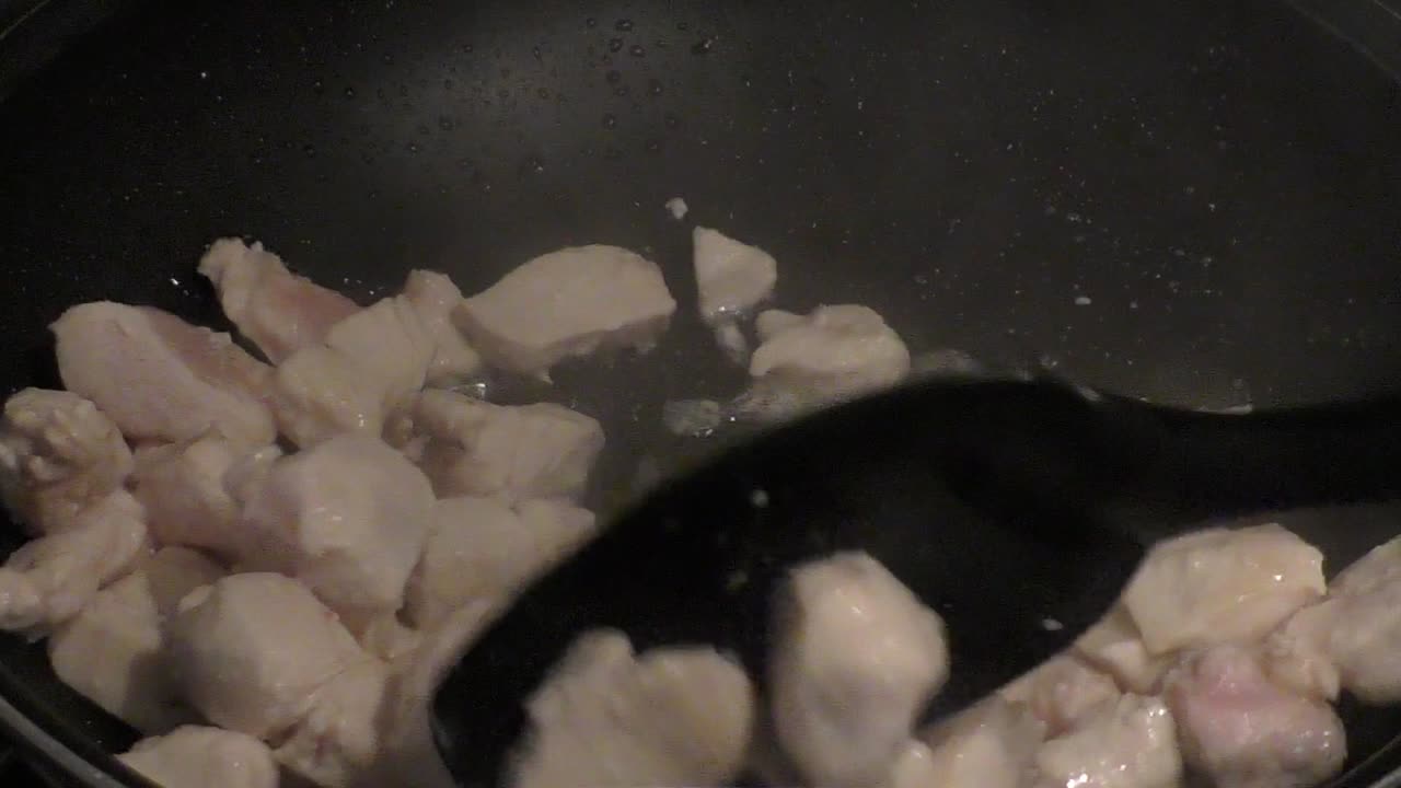 carne di pollo fritta in padella nera.