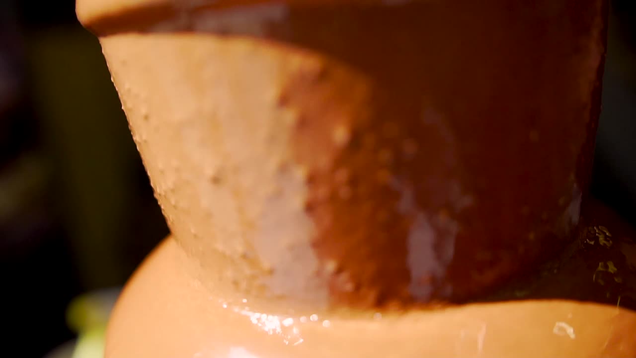 Fontana di cioccolato al latte liquido per dessert fonduta in primo piano