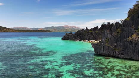 Bird's-eye survey of the turquoise waters and rocky hills at Smith Point Beach, Coron, Philippines